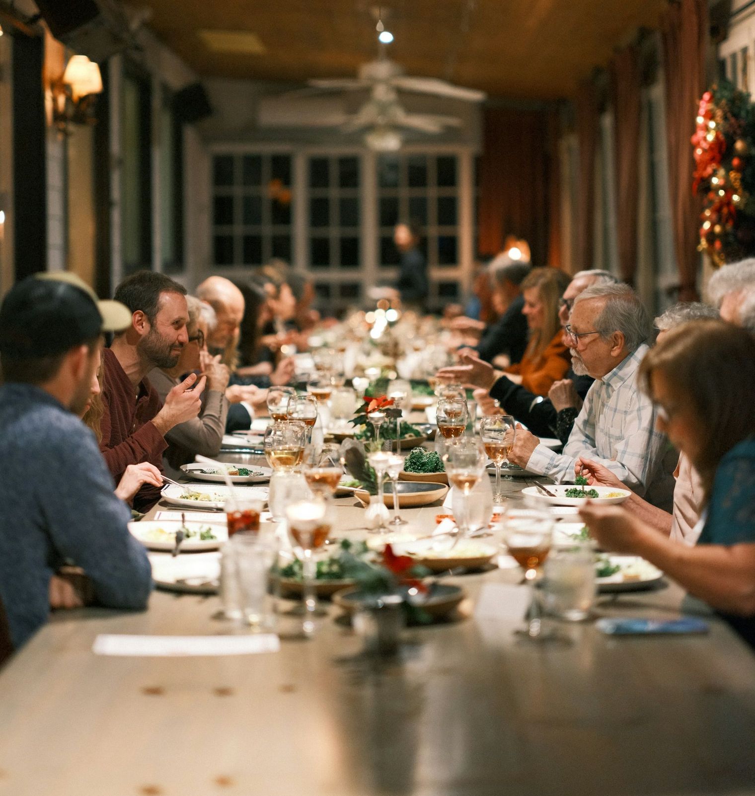 Viele Menschen sitzen an langer Tafel und essen gemeinsam.