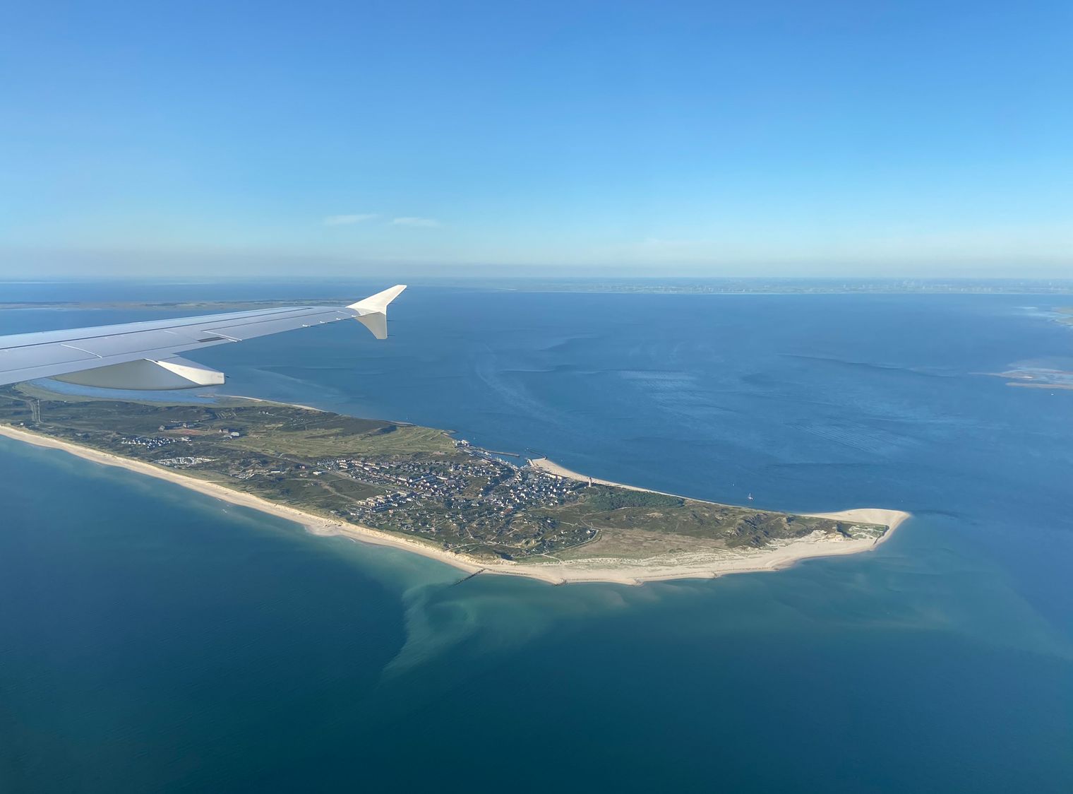 Flugzeugflügel über Sylts Südspitze mit Hörnum und Nordsee.
