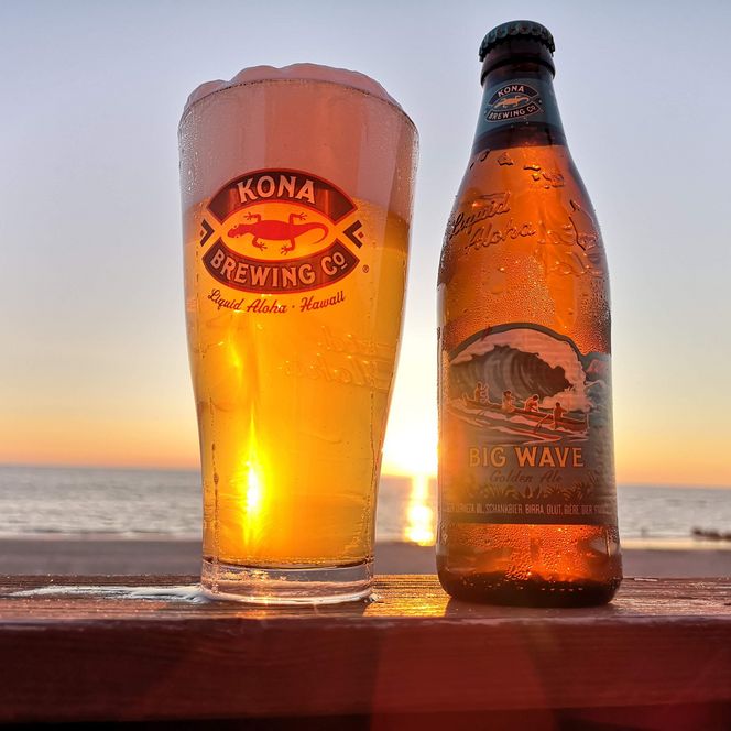 Bierflasche und Glas vor Sonnenuntergang am Meer