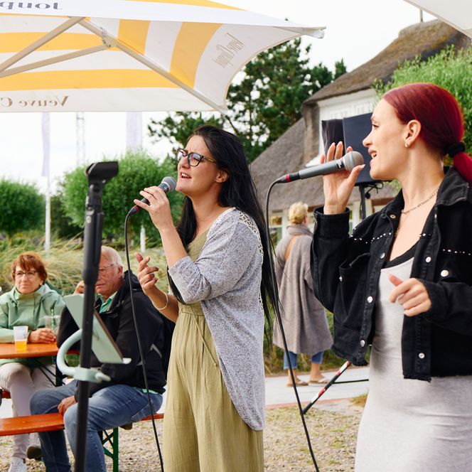 Zwei Sängerinnen performen auf offener Straße vor Publikum
