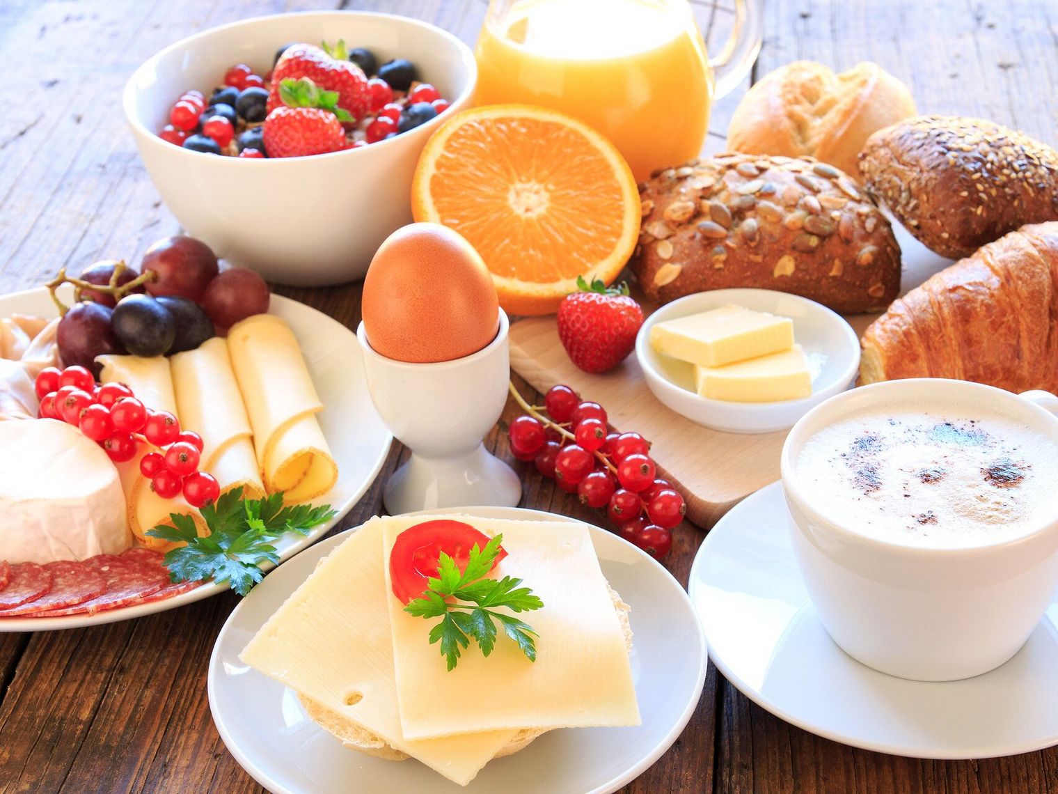 Frühstück mit Brötchen, Ei, Obst und Kaffee