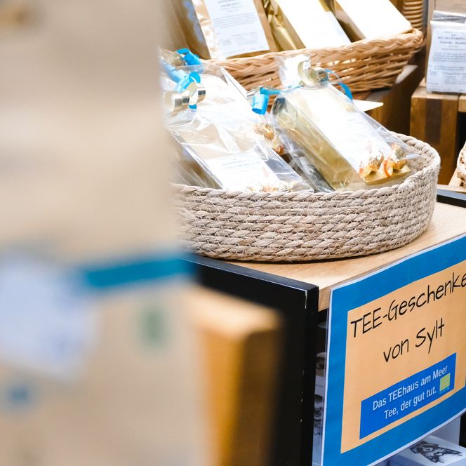 Korb mit Teepackungen und Schild „Tee-Geschenke von Sylt“