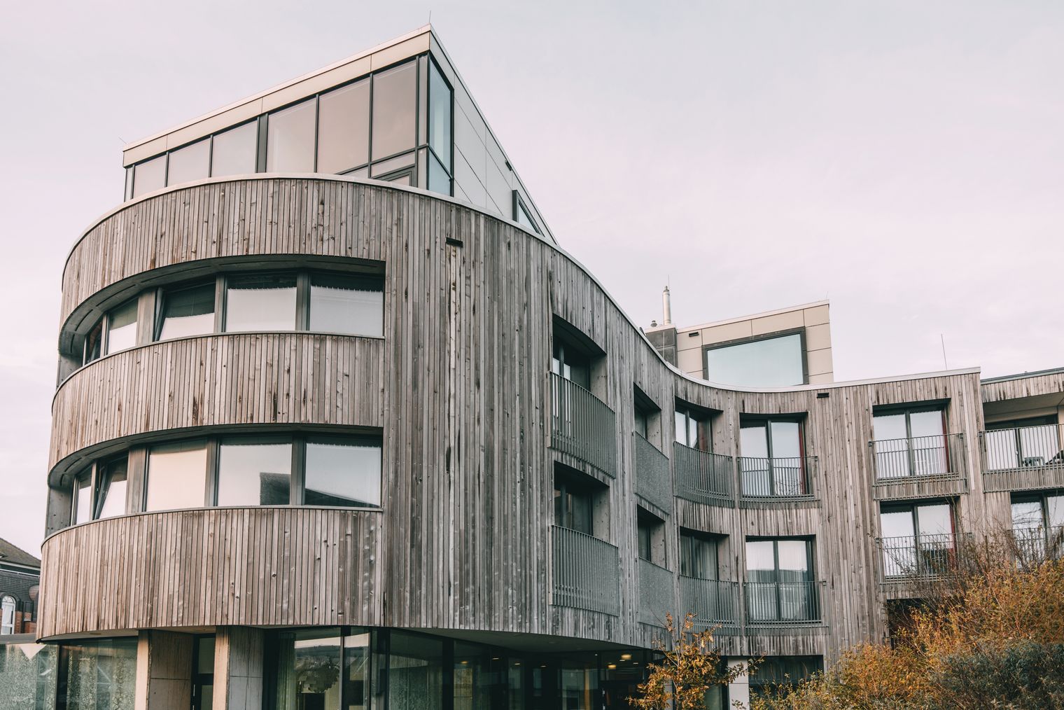 Modernes Hotel mit Holzfassade und geschwungener Form in Westerland