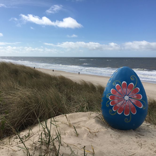 Großes, bemaltes Osterei in den Dünen am Strand von Westerland.