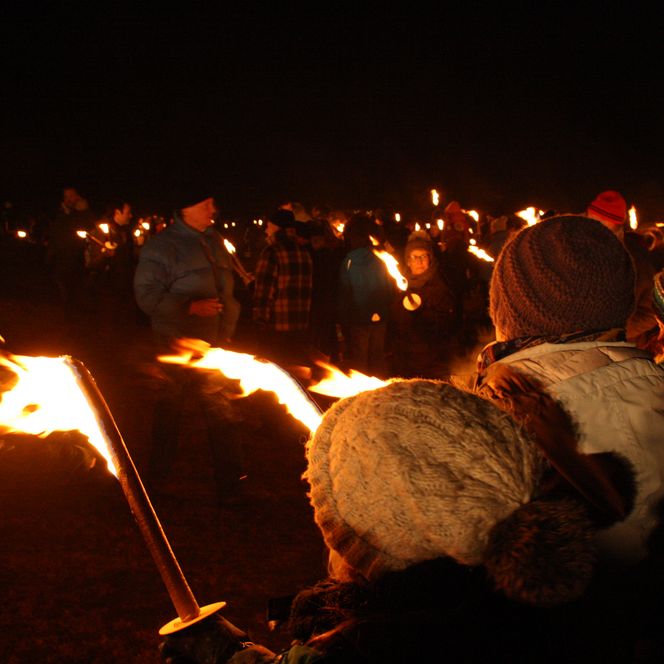 Menschen mit Fackeln im Dunkeln um die Biike