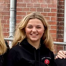 Vier junge Frauen in schwarzer Sylt-Kleidung vor rotem Backsteingebäude