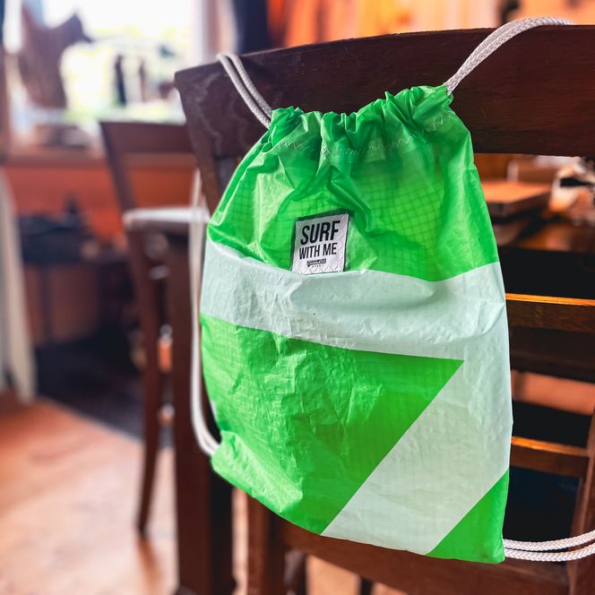 Grüner Beutel mit „Surf with me“-Aufdruck im Shop.
