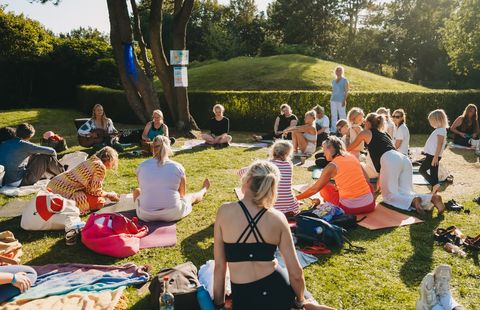 Gruppe sitzt im Kreis bei Yoga im Park