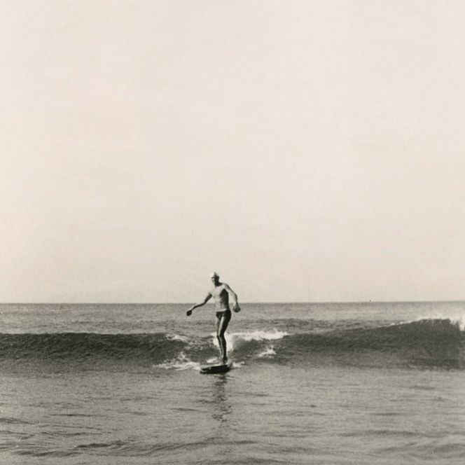 Mann surft 1952 auf kleiner Welle vor Sylt
