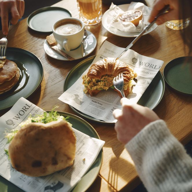 Vielfältiger Frühstücksgenuss in geselliger Runde Frühstück mit Pancakes, Croissant-Sandwich und Getränken