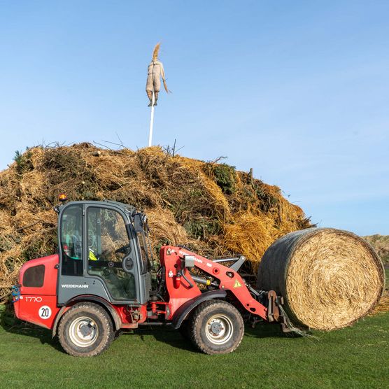 Bagger schichtet Biikehaufen auf