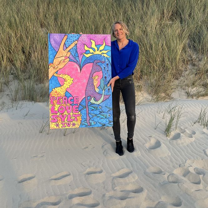 Künstlerin mit Gemälde am Strand