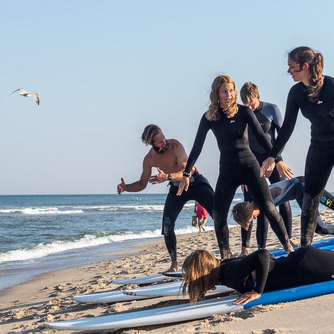 Jugendliche mit Surfbrett machen Trockenübungen