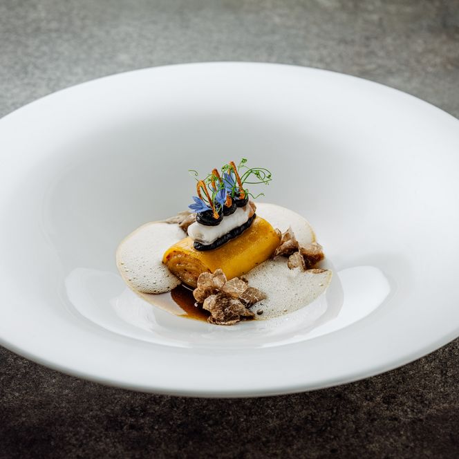 Fein angerichtetes Pastagericht mit Schaum, Trüffel und Blüten beim Private Dining auf Sylt.