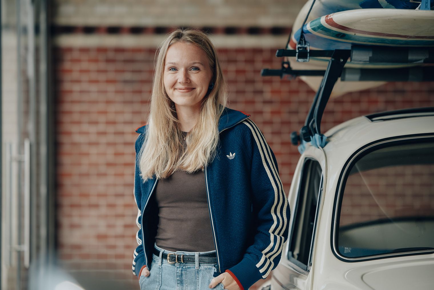 Tabea Olsson von Sylt Marketing steht neben einem weißen Fahrzeug mit Dachboards in einer Garage.