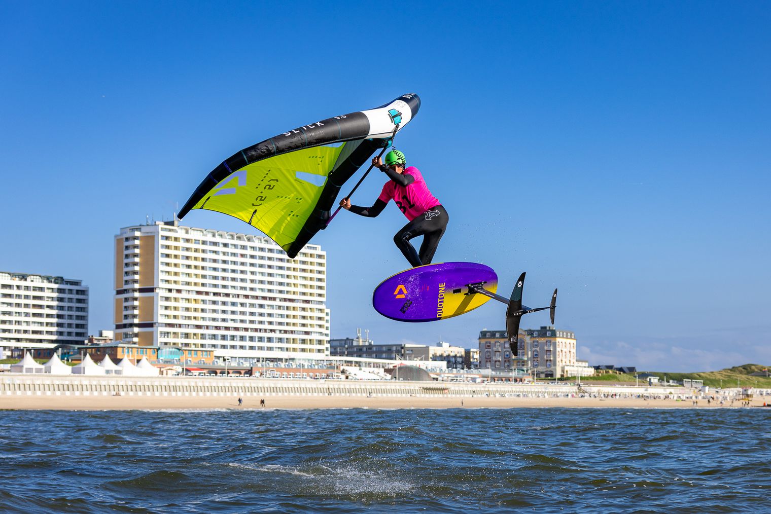 Wingfoiler springt vor Kulisse von Westerland
