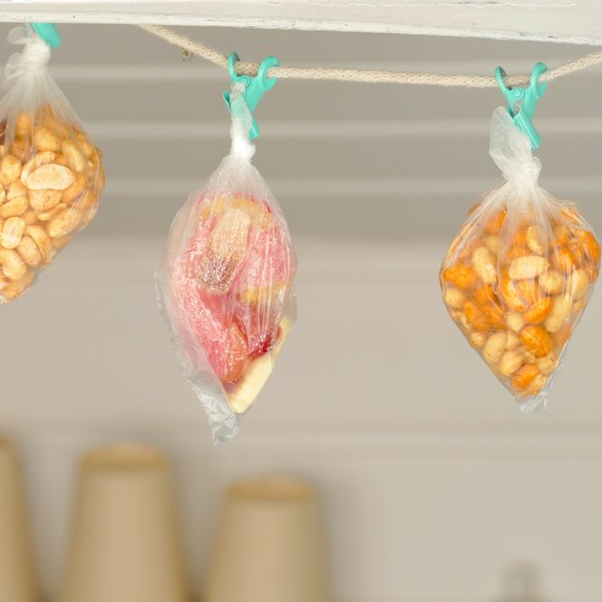Drei Snacktüten hängen an Wäscheklammern auf einer Leine