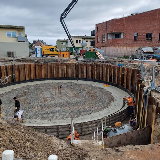 Bauarbeiter arbeiten an rundem Eisspeicher-Fundament im Neubaugebiet in Westerland.