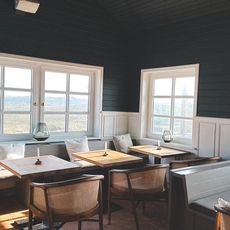 Heller Restaurantbereich mit Tischen und Blick auf Dünen