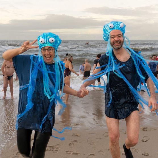 Paar beim Neujahrsbaden in Quallenkostümen