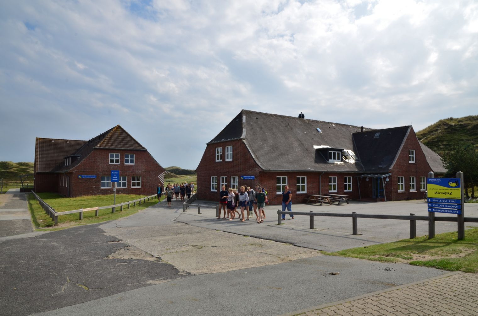 Zwei Backsteingebäude der Jugendfreizeitstätte Mövenberg mit Jugendgruppe davor