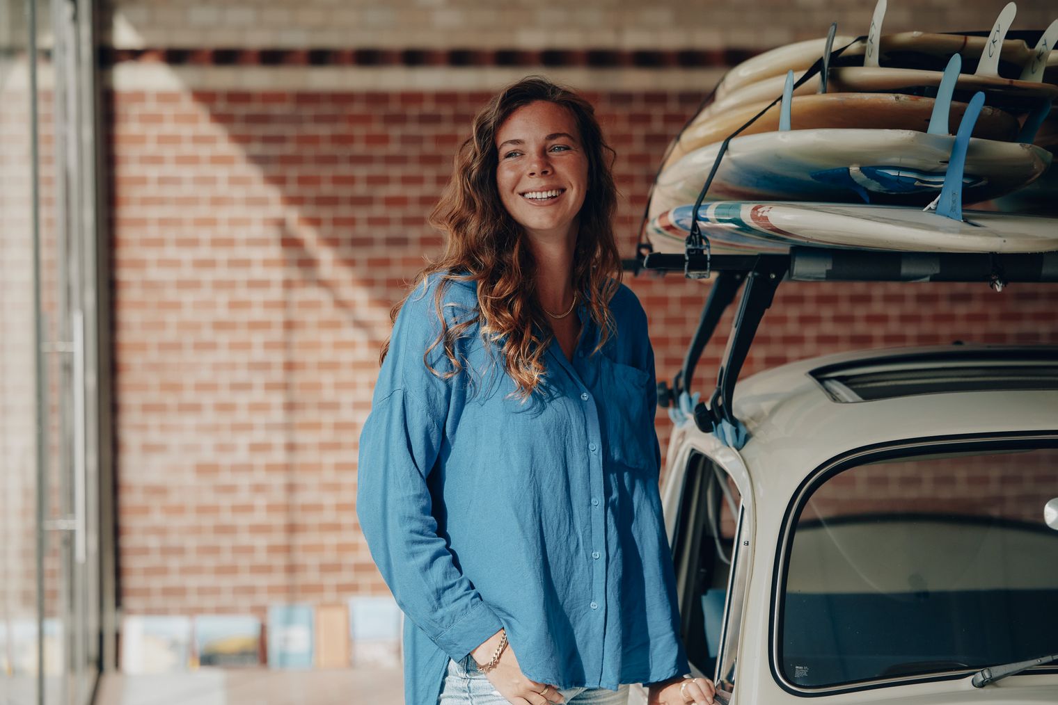 Natalie Waletzko von Sylt Marketing neben einem Auto mit Surfbrettern auf dem Dach