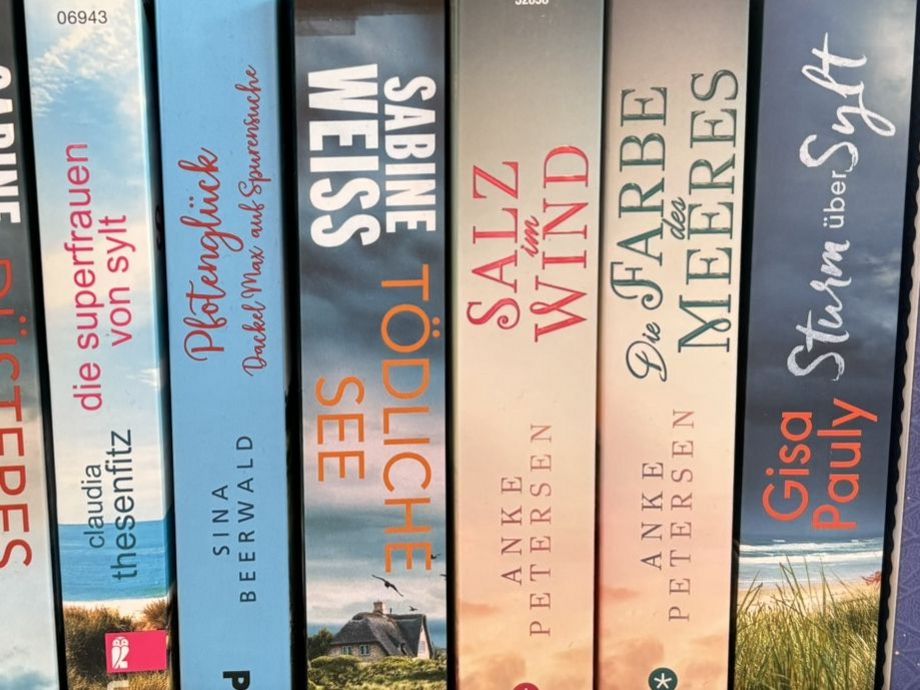 Sylt-Lektüre im Regal Regal mit verschiedenen Sylt-Romanen bekannter Autorinnen.