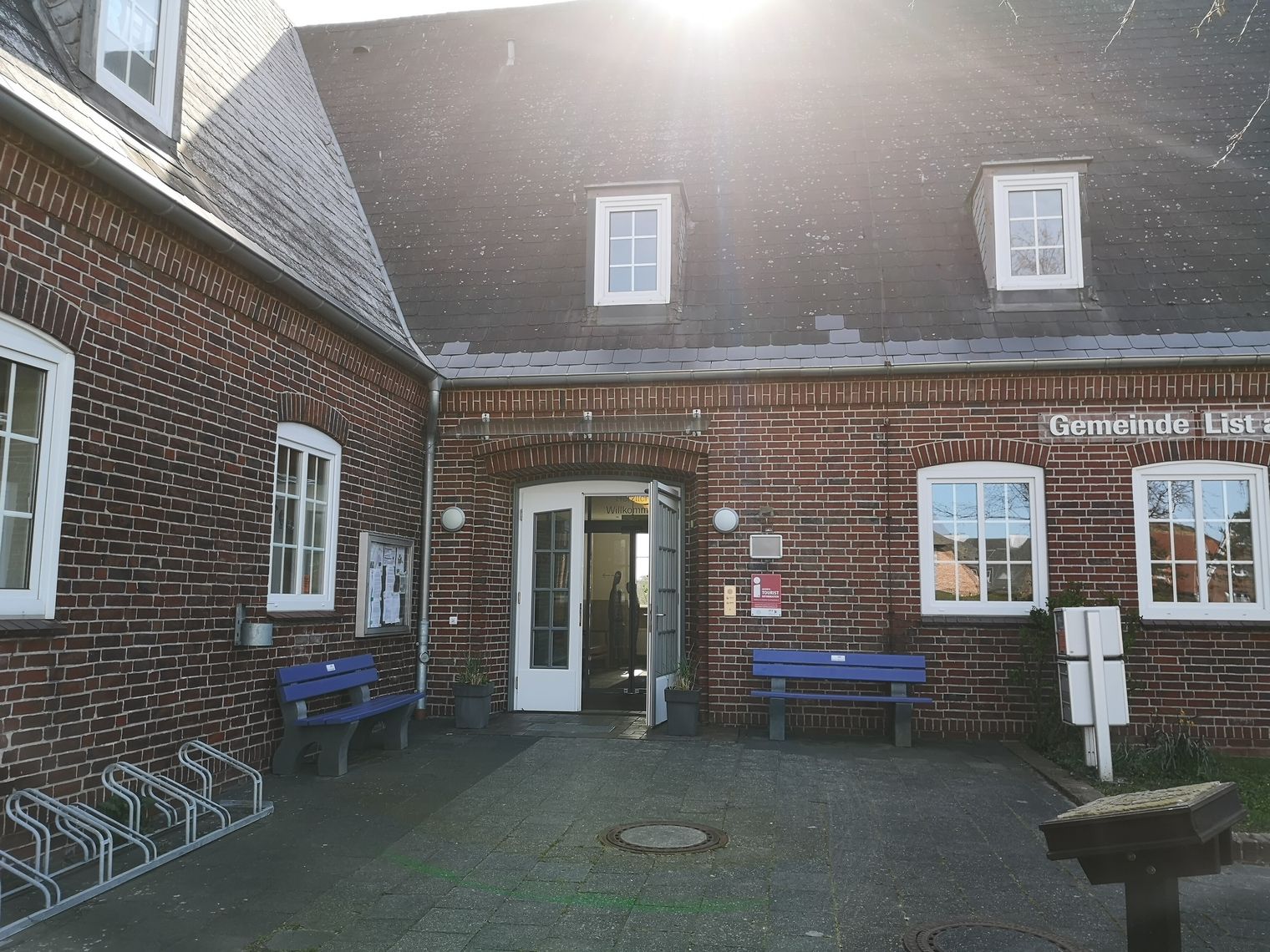 Die Gebäude der Kurverwaltung List auf Sylt mit der offenen Eingangstür.