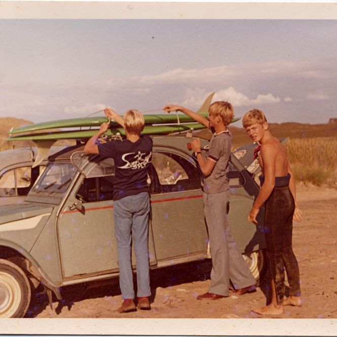 Drei Jungen laden Surfbrett auf 2CV in Sylter Dünen