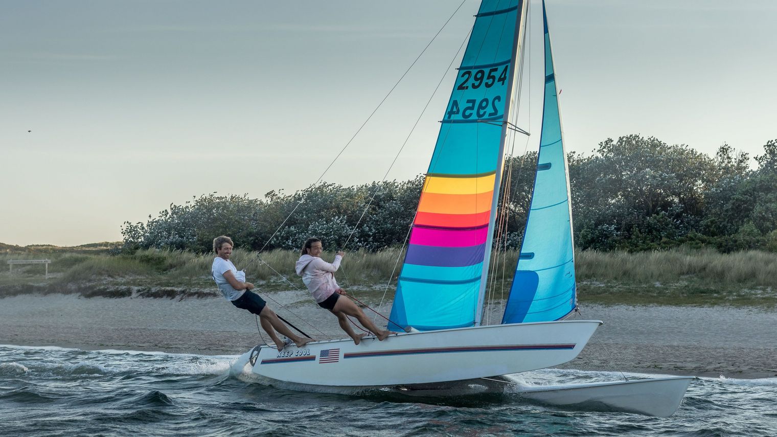 Zwei Personen segeln auf einem Katamaran