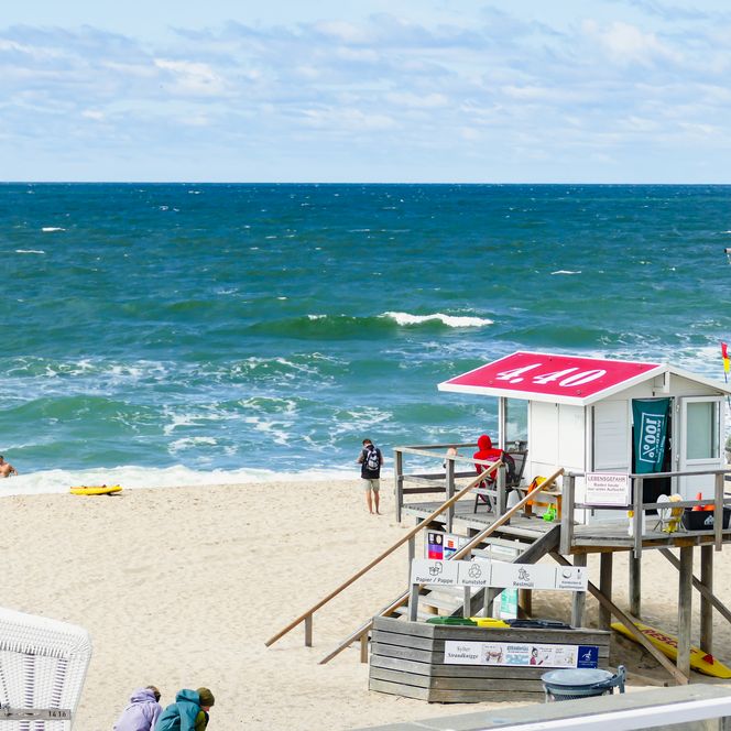 Rettungsturm am Strand mit Badegästen und Wellengang