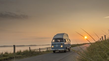 Blauer VW-Bulli am Ellenbogen auf Sylt bei Sonnenuntergang.