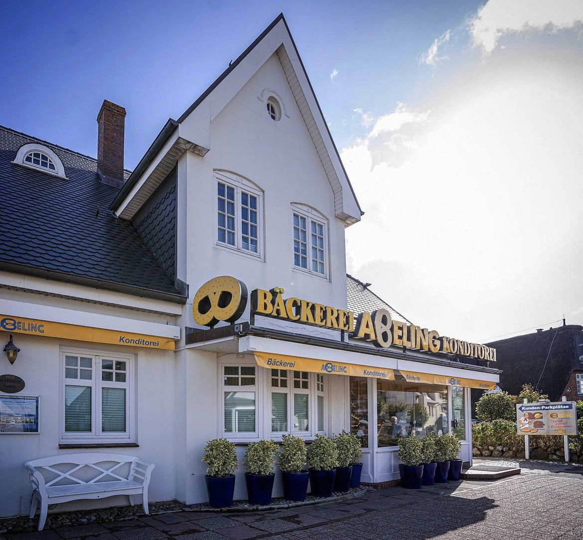 Weiße Bäckerei mit gelben Markisen und Giebeldach auf Sylt.