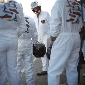 Gruppe in weißen Overalls mit Helmen, Festivalaufdruck.