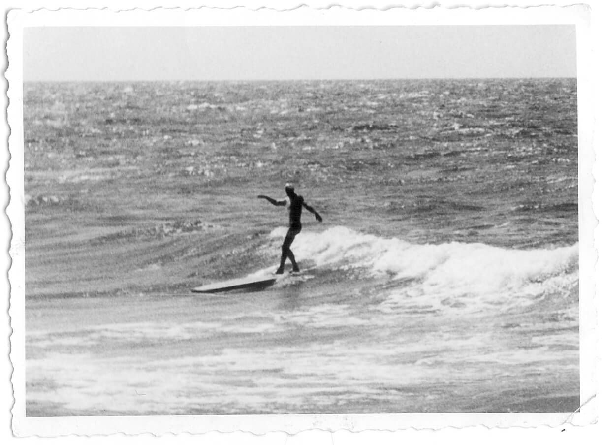 Historisches Schwarz-Weiß-Foto eines Surfers auf einer kleinen Welle